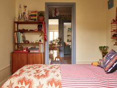 a bedroom with a bed, desk and bookshelf in the corner next to an open door