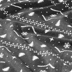 a black and white photo of a blanket with christmas trees on it's side