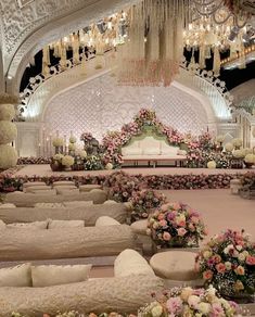 an elaborately decorated room with couches and flowers on the floor, chandeliers hanging from the ceiling