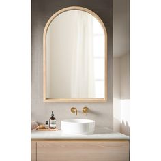 a bathroom sink under a large oval mirror