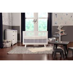 a baby's room with a white crib and gray walls