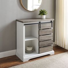 a white cabinet with drawers and a mirror on the wall