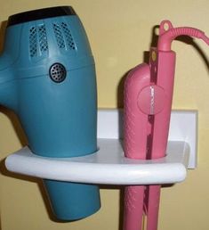 a hair dryer sitting on top of a shelf next to a blow dryer