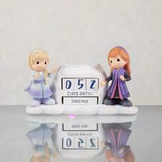 two figurines sitting on top of a table