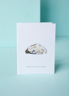 a card with an image of a sea shell on the front, and text that reads'the world is your oyster '