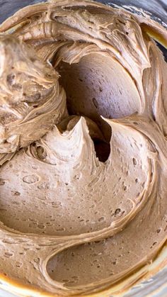 a bowl filled with chocolate frosting sitting on top of a table