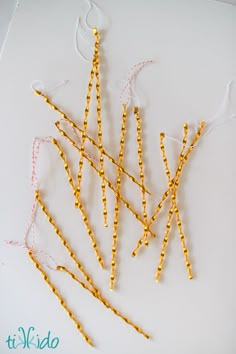 several yellow straws are arranged on a white surface and tied together with twine