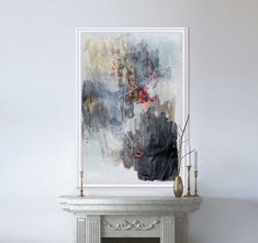 a painting is hanging on the wall next to a fire place with candles and vases