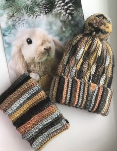 two crocheted hats, one with a rabbit on it and the other with a knitted hat