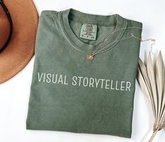 Celebrate your passion for capturing moments with our Visual Storyteller Photographer Shirt. This stylish and comfortable photography shirt is perfect for photographers, videographers, and visual storytellers. Whether you're out on a shoot, editing your latest project, or simply want to showcase your love for the craft, this photographer tee is an essential addition to your wardrobe. Key Features: - Creative Design: The Visual Storyteller message on this photographer shirt perfectly captures the essence of what it means to be behind the lens. It's also a great funny photographer tee that adds a touch of humor to your gear. - High-Quality Material: Made from soft, durable Comfort Colors fabric, this photographer tshirt ensures all-day comfort and longevity, making it ideal for long shoots o Photographer Tshirt Ideas, Comfortable Photography, Tee Photography, Photographer Gear, Photographer Tshirt, Photography Shirt, Gift For Photographer, Photographer Humor, Photography Shirts