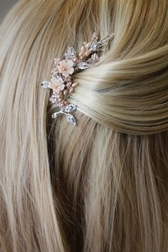 a woman with blonde hair is wearing a pink flower and crystal hair clip on her head