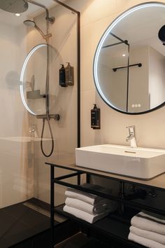 a bathroom with a sink, mirror and shower stall in it's own area