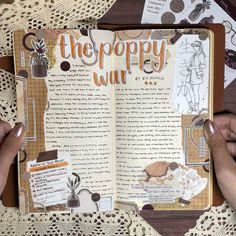 someone holding an open book on top of a doily covered table with crochet