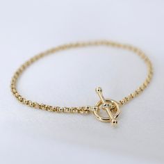 "14K GoldToggle Rolo Chain Bracelet - 14K Gold 2mm Rolo Chain Bracelet ★ 14K gold 2mm rolo chain ★ 14K gold toggle clasp ★ All components are 14K solid yellow gold The length includes the chain and the closure. Please measure your wrist before you place your order. ** How to choose a correct size of bracelet. 1. Measure your wrist below the wrist bone using a flexible tape measures, a string or a strip of paper. 2. If using a string or a strip of paper, mark length. Then, measure it with a ruler Yellow Gold Plated Bracelet With Toggle Clasp, Yellow Gold-plated Bracelet With Toggle Clasp, Timeless 14k Gold Chain Bracelet With Spring Ring Clasp, Gold Chain Bracelet For Everyday, Classic Gold Bracelet With Toggle Clasp, Classic Gold-tone Bracelets With Toggle Clasp, Everyday Yellow Gold Chain Bracelet With Toggle Clasp, Everyday Yellow Gold Bracelets With Toggle Clasp, Classic Gold Bracelets With Rolo Chain