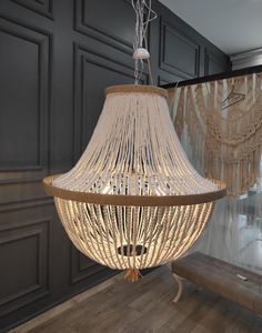 a chandelier hanging from the ceiling in a room with wood floors and walls