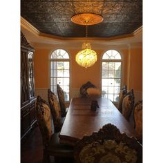 a dining room table and chairs with chandelier hanging from it's ceiling