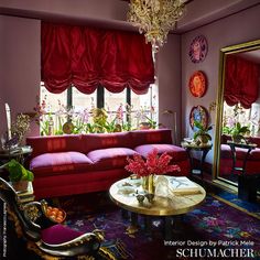 a living room filled with furniture and a chandelier hanging from the ceiling next to a window