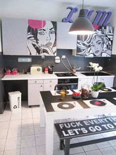 a kitchen with black and white decor on the walls, an island table in the middle