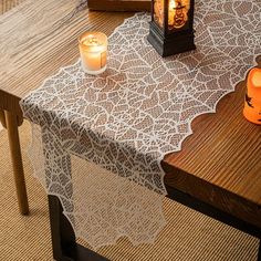 a table with two candles on it and a lace doily covering the table top