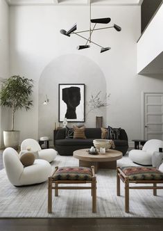 a living room filled with furniture and a large painting hanging above the couches on the wall