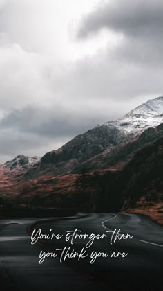 a road with mountains in the background and a quote on it that says you're longer than you think you are