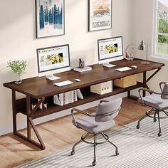 two computer desks sitting on top of a hard wood floor next to a window