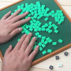 two hands on a board with dices in the shape of a tree and one hand reaching for it