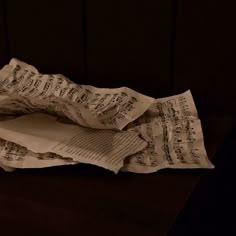 an open book with sheet music on it sitting on top of a wooden table next to a cell phone