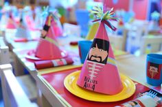 a table set with plates, cups and napkins for children's birthday party