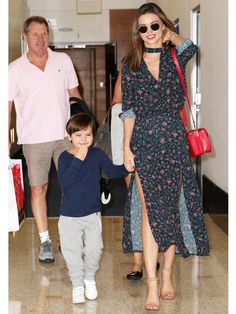 a woman and child walking through an airport with their hands in each other's pockets