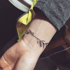 a woman's wrist with a small tattoo on her left hand and an arrow in the middle