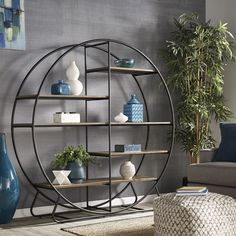 a living room filled with furniture and a round shelf next to a plant in a vase