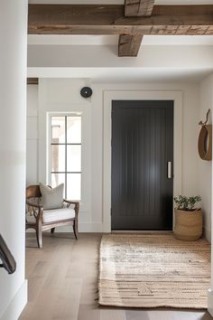 an entryway with a black door and white walls