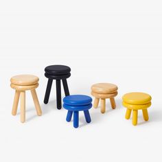 four stools in various colors and sizes on a white background, one is black, the other is yellow