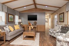 a living room filled with furniture and a flat screen tv mounted to the wall over a fireplace