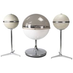 three white and chrome colored balls on stands