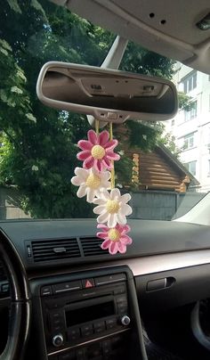 flowers are hanging from the dashboard of a car