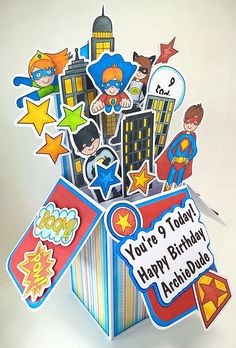 a birthday card in a pop up box with superheros and stars on the top