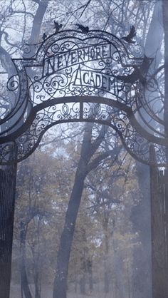 an iron gate with the words nevermore alcaad on it in front of trees