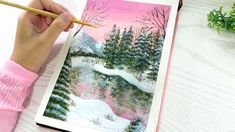 a person is holding a pencil in their hand while painting a landscape with watercolors