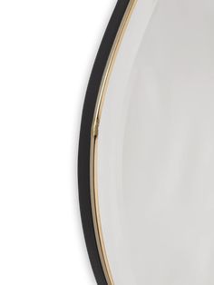 a black and gold mirror on a white wall