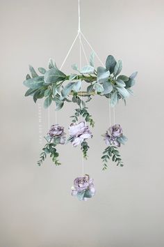 a mobile with flowers hanging from it's sides