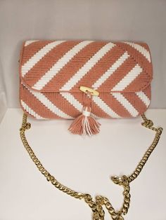 an orange and white striped purse sitting on top of a table next to a chain