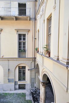 an apartment building with two balconies on the second floor and several bicycles parked outside