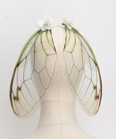 the back of a mannequin's head with wings and flowers on it