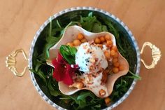 a bowl filled with lots of food on top of a wooden table