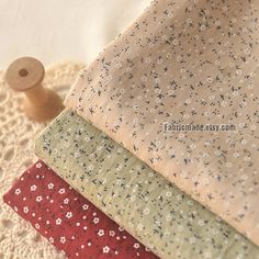 four different types of fabric sitting on top of a doily