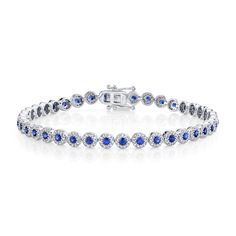 Rich in color, she will love the deep blue hues in this bracelet from Shy Creation. Crafted in 14k white gold, this bracelet features a row of blue sapphire gemstones surrounded by sparkling round diamonds in a halo motif. This bracelet measures 4.5mm in width and 7 inches in length. The diamonds are 1 1/4ctw, H in color, and SI2 in clarity. Blue Jubilee Tennis Bracelet Fine Jewelry, Blue Brilliant Cut Diamond Bracelet, Blue Diamond Bracelet With Brilliant Cut, Blue Diamond Bracelets With Brilliant Cut, Blue Sapphire Round Bracelet, Blue Sapphire Diamond Round Bracelet, Blue Sapphire Gemstone Tennis Bracelet, Blue Sapphire Tennis Bracelet With Gemstone, Blue Diamond Jubilee Tennis Bracelet