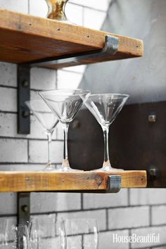 two wine glasses sitting on top of a wooden shelf