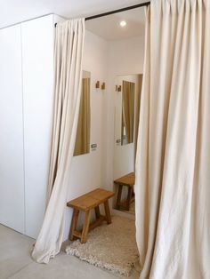 a room with white walls and beige curtains